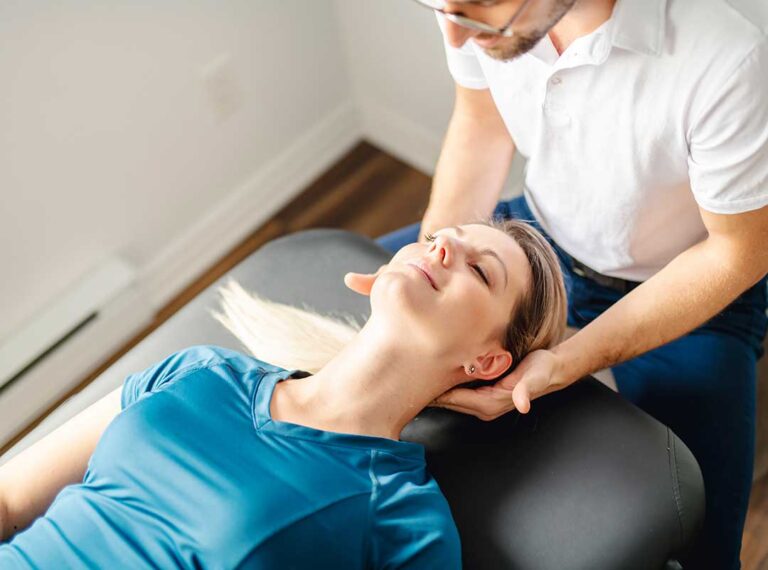 A chiropractor performing a spinal adjustment on a patient in a calm clinical setting.
